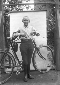 853687 Portret van een onbekende jongen met een fiets.